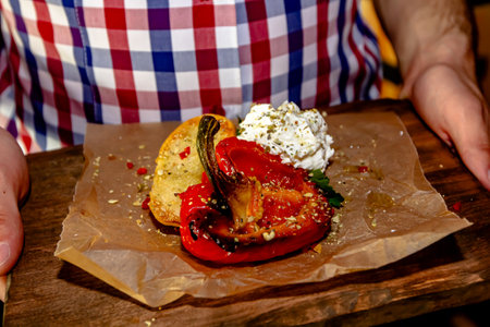 Grilled red bell pepper and feta cheese on a wooden boardの写真素材