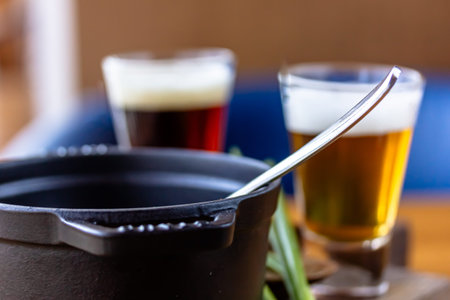 two glasses of beer on a wooden table in a restaurant, close-upの写真素材