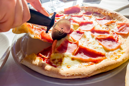 pizza with ham and mozzarella on the table in restaurant
