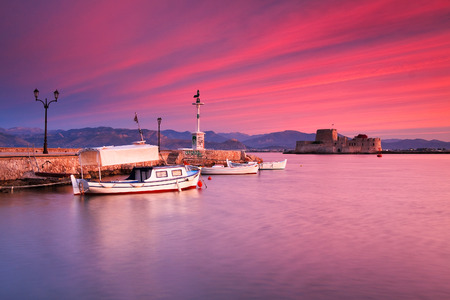 Fishing boats and Bourtzi castle in the Nafplio harbour in Peloponnese peninsula, Greece.の写真素材