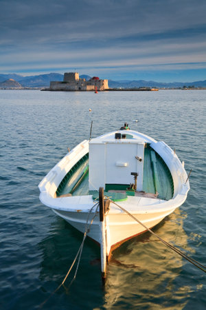 A fishing boat in Nafplio harbour and Bourtzi castle, Greece.のeditorial素材