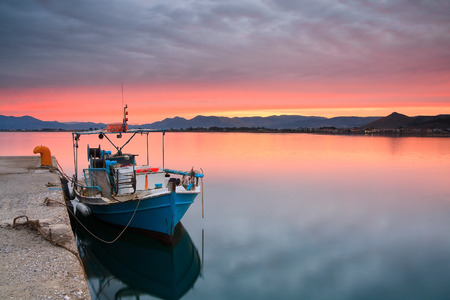 Fishing boat at sunset in Nafplio harbour, Greece.の写真素材