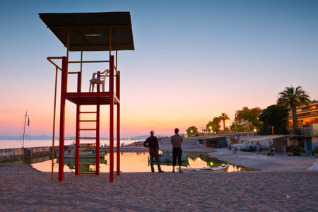 Fishing boats and a lifeguard lookout tower on a beach in Palaio Faliro in Athens, Greeceのeditorial素材