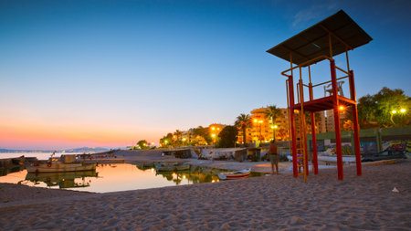 Fishing boats and a lifeguard stand on a beach in Palaio Faliro in Athens, Greece