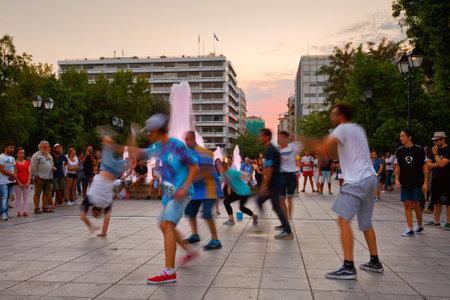 Group of street artists performing in Syntagma square attracting a crowd of spectatorsのeditorial素材