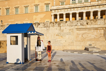 Girl posing for photograph with a guard in front of the building of Greek parliamentのeditorial素材