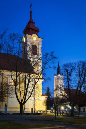 Classicistic Roman Catholic and Calvinist churches in the town of Rimavska Sobota, Slovakia.の写真素材