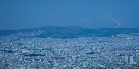 View of Aigaleo mountain and city of Athens from Lycabettus hill during a summer storm, Greece.