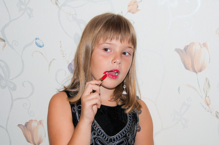 Girl with red lipstick in hand and red make upの写真素材