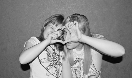 Mother and daughter sitting together in black and show heartの写真素材