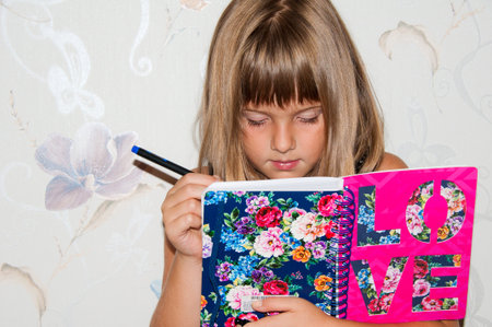 Teen girl writing in notebookの写真素材