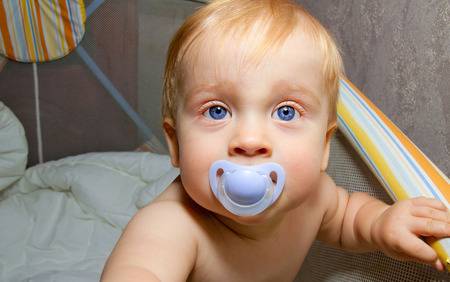 Baby boy blue eyes with blue sootherの写真素材