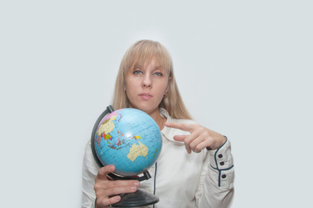 Young Blond woman shows globe in hands