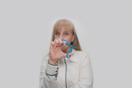 Young blond Woman with scissors in right hand