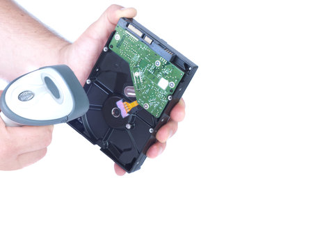 Two male hands. In his left hand man holding a hard drive in the right hand man holding the scanner....