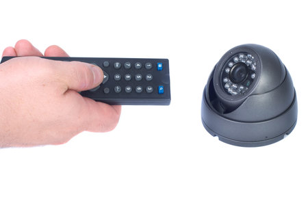 Man`s hand with remote and security camera isolates white