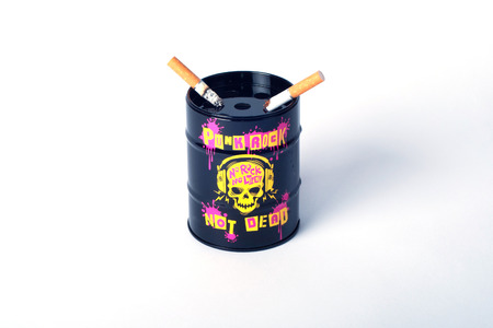 Two cigarette and ashtray in the form of black cans with funky slogansの写真素材