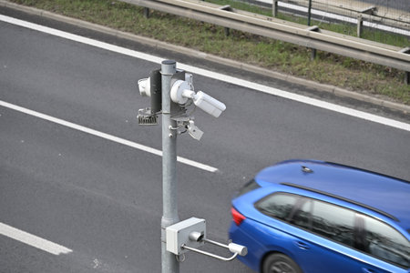 Traffic monitoring equipment on the road with a blue car in the backgroundの写真素材