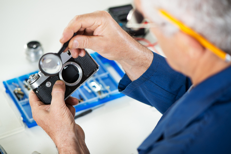 Repairman checking Old Rangefinder Cameraの写真素材