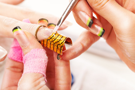 A young beautiful woman doing nail extension in the beauty salon.の写真素材
