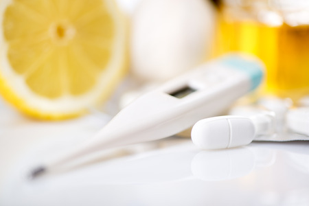Vitamins and pills for treatment Cold And Flu. Lemon,  honey and Thermometer on white .の写真素材