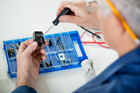 Electrician checking old power plug. Close-up. Selective focus, Focus on power plug. の写真素材