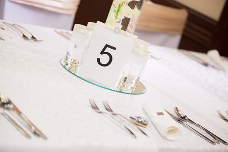 Place setting and card on a table at a wedding receptionの写真素材
