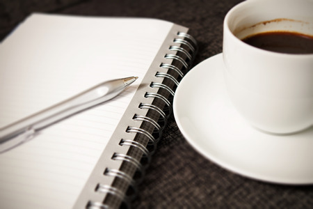 Coffee cup, notebook and penの写真素材