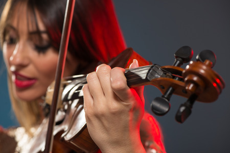 Close-up of a violin played by a young woman with a face out of focus.の写真素材