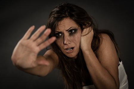 Young abused woman defending with pray looking and outstretched arm.の写真素材