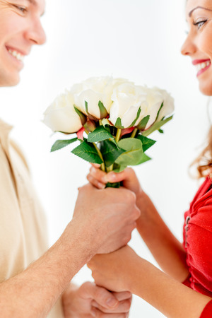 Happy loving couple holding bouquet white roses. Selective focus. Focus on roses.の写真素材