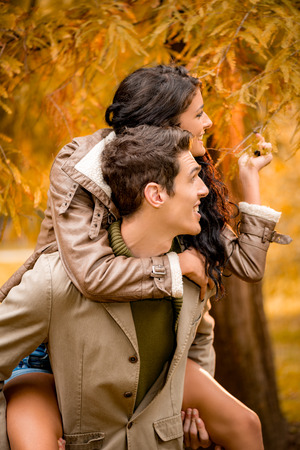Beautiful young couple enjoying autumn day in the park.の写真素材