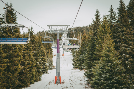 Ropeway and chair lifts driving at ski resort on beautiful snowing day. Landscape.の写真素材