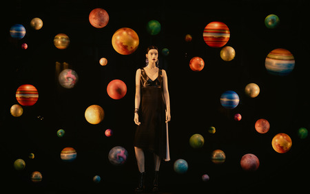 The female mannequin in a shop window which is decorated with many colorful planets.の写真素材