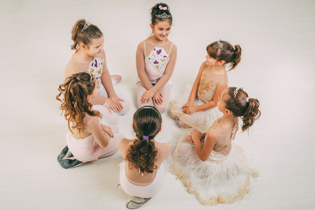 Group of a little girls in dresses taking a break from ballet class.の写真素材