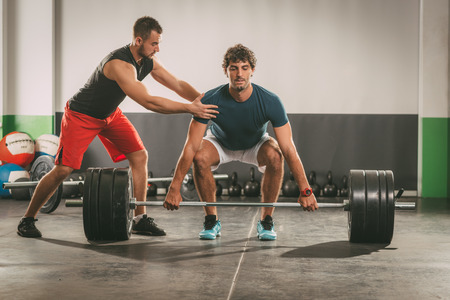 Young man doing crossfit workout with a personal trainer.の写真素材