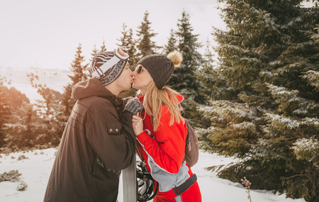 Beautiful young couple kissing and enjoying in winter vacations. の写真素材