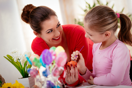 Beautiful happiness mother and daughter painting Easter egg at home.の写真素材
