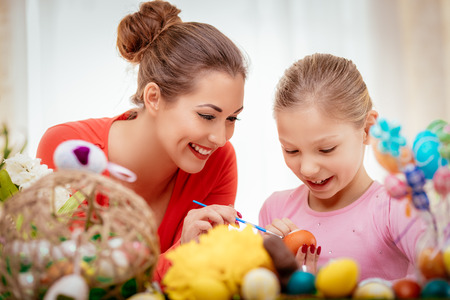 Beautiful happiness mother and daughter painting Easter egg at home.の写真素材