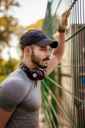 Young pensive sportsman resting after training in nature and looking away.の写真素材
