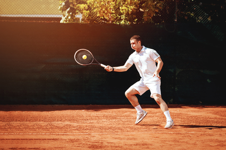 Beautiful young man playing tennis match.の写真素材
