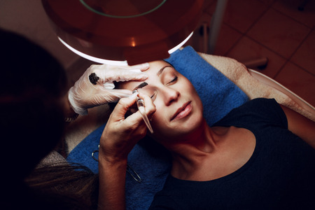 Beautician applying japanese method of drawing on eyebrows to model.の写真素材