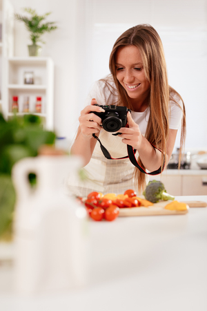 Beautiful young woman taking photo of healthy salad with digital photo camera for her blog.の写真素材