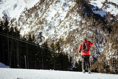 Rear view of a man walking on mountain covered snow.の写真素材