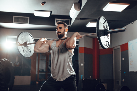 Young muscular man lifting a barbell at the gym.の写真素材