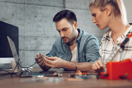 Two young business partners technician focused on the repair of electronic equipment.の写真素材
