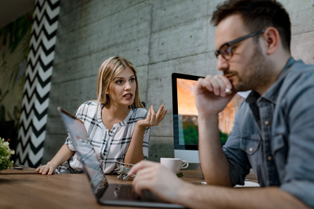 Young business colleagues analyzing project and working on a laptop in the office. の写真素材