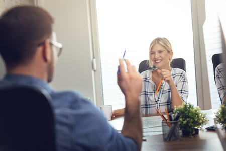 Young successful architect colleagues talking while working on a new project at the office.の写真素材