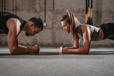 Young muscular couple doing push-up exercise at the cross fit workout.の写真素材