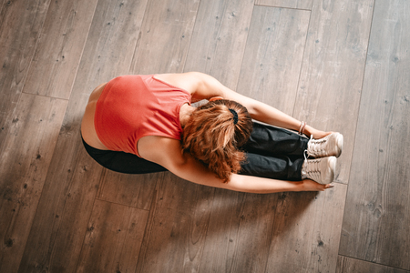 Above view of a woman doing stretching exercises on floor.の写真素材